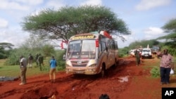 FILE - Kenyan security forces and others gather around the scene on an attack on a bus about 50 kilometers (31 miles) outside the town of Mandera, near the Somali border in northeastern Kenya, Nov. 22, 2014.