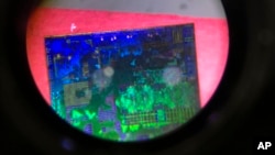 A Chinese microchip is seen through a microscope set up at the booth for the state-controlled Tsinghua Unigroup project which is driving China's semiconductor ambitions during the 21st China Beijing International High-tech Expo in Beijing, China, May 17, 2018.