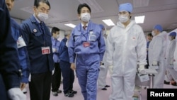 Japan's new prime minister, Shinzo Abe (C), tours the emergency operations center of the crippled Fukushima nuclear power plant December 29, 2012.