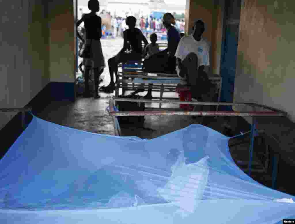 A man waits inside a mosquito tent in a school to vote near a polling station during a referendum in Abyei, Oct. 27, 2013. 