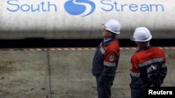Employees stand near pipes made for the South Stream pipeline at the OMK metal works in Vyksa in the Nizhny Novgorod region, April 15, 2014. 