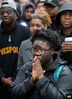 Boston College student Akosua Opokua-Achampong, of Lake Hopatcong, N.J., places her hands together during a solidarity demonstration on the school's campus, in Newton, Mass., Nov. 12, 2015.