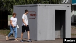 People walk past a reinforced-concrete bomb shelter installed on a street in Kursk, Russia, on Aug. 28, 2024. The sign on the structure reads, "Shelter."