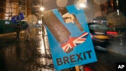Vehicles drive past an anti-Brexit placard that is placed near the Parliament in London, Jan. 29, 2019.