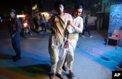 An injured boy is held up outside a hospital following a deadly attack in Kabul, Afghanistan, Sept. 5, 2018.
