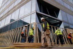 Workers board up buildings near the White House prior to the presidential inauguration in Washington, Jan. 14, 2021.