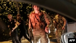 FILE - Turkish security officers detain Turkish police officers (in black) in Istanbul, during a security shutdown of the Bosphorus Bridge, July 15, 2016. 