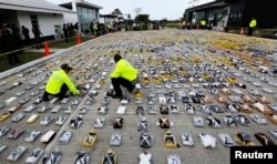 FILE - Colombian anti-narcotics policemen inspect packs of cocaine at the police base in Necocli, Feb. 24, 2015.
