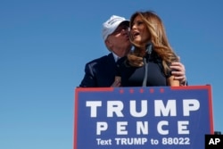 FILE - Republican presidential candidate Donald Trump kisses his wife, Melania, during a campaign rally in Wilmington, N.C., Nov. 5, 2016.
