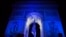 People gather at the Arc de Triomphe lit up in blue to mark the French presidency of the European in Paris, Jan. 1, 2022. 
