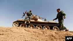 Members of Kurdish Peshmerga forces hold their position in the Iraqi village of Basheer, 15 kilometers south of the city of Kirkuk, June 21, 2014.