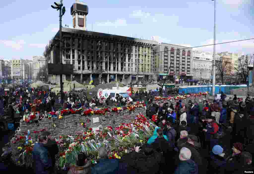 People lay flowers at the barricades in memory of the victims of the recent clashes in central Kyiv, Feb. 24, 2014. 