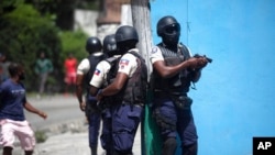 Police officers with their weapons drawn search for suspects in the killing of Haiti's President Jovenel Moise, in Port-au-Prince, Haiti, July 8, 2021.