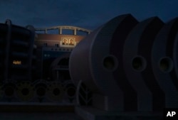 In this Oct. 22, 2018, photo, portraits of North Korean late leaders Kim Il Sung and his son Kim Jong Il are illuminated on the facade of a building in Wonsan, North Korea.