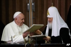Pope Francis, left, and Russian Orthodox Patriarch Kirill exchange a joint declaration on religious unity at the Jose Marti International airport in Havana, Cuba, Feb. 12, 2016.