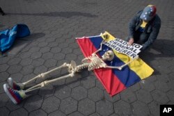 A supporter of Venezuelan opposition leader Juan Guaido secures a skeleton to a Venezuelan flag during a rally in New York's Union Square, April 30, 2019.