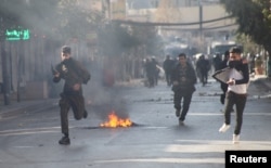 Kurdish protesters run away from tear gaz during a rally against the Kurdistan Regional Government (KRG) in Sulaimaniyah, Iraq, Dec. 18, 2017.