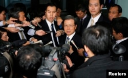 FILE - Cheng Yonghua, center, Chinese ambassador to Japan, is surrounded by the media as he speaks after meeting with Japan's Vice Minister for Foreign Affairs Akitaka Saiki at the Foreign Ministry in Tokyo, Nov. 25, 2013.