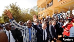 French President Emmanuel Macron and Burkina Faso's President Roch Marc Christian Kabore leave the Ouagadougou University, in Ouagadougou, Burkina Faso, Nov. 28, 2017.