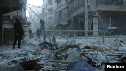 Residents look out for warplanes while standing at a damaged site after what activists said was an air raid by forces loyal to Syrian President al-Assad, in Aleppo's district of al-Sukari, Feb.1, 2014. 