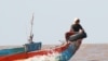 A fisherman sit on atop of a boat on Tonle Sap Lake,​ near Siem Reap province. The hot weather has caused the fish to stay in deep water, which make fishermen have difficult in fishing, and get less stock of fishes. (Nov Povleakhena/VOA Khmer)