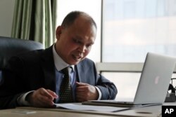 Chinese lawyer Yu Wensheng checks on his lawsuits at his office in Beijing, Feb. 24, 2017. Yu’s wife says her husband was taken into police custody on Jan. 19, 2018, while taking his son to school, a day after he posted a letter online calling on China's ruling communist party to reform the Chinese constitution and allow open presidential elections.
