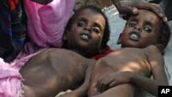 Two Somali children suffering from malnutrition lie at a camp for Internally Displaced People (IDP) near Mogadishu airport, July 2011.