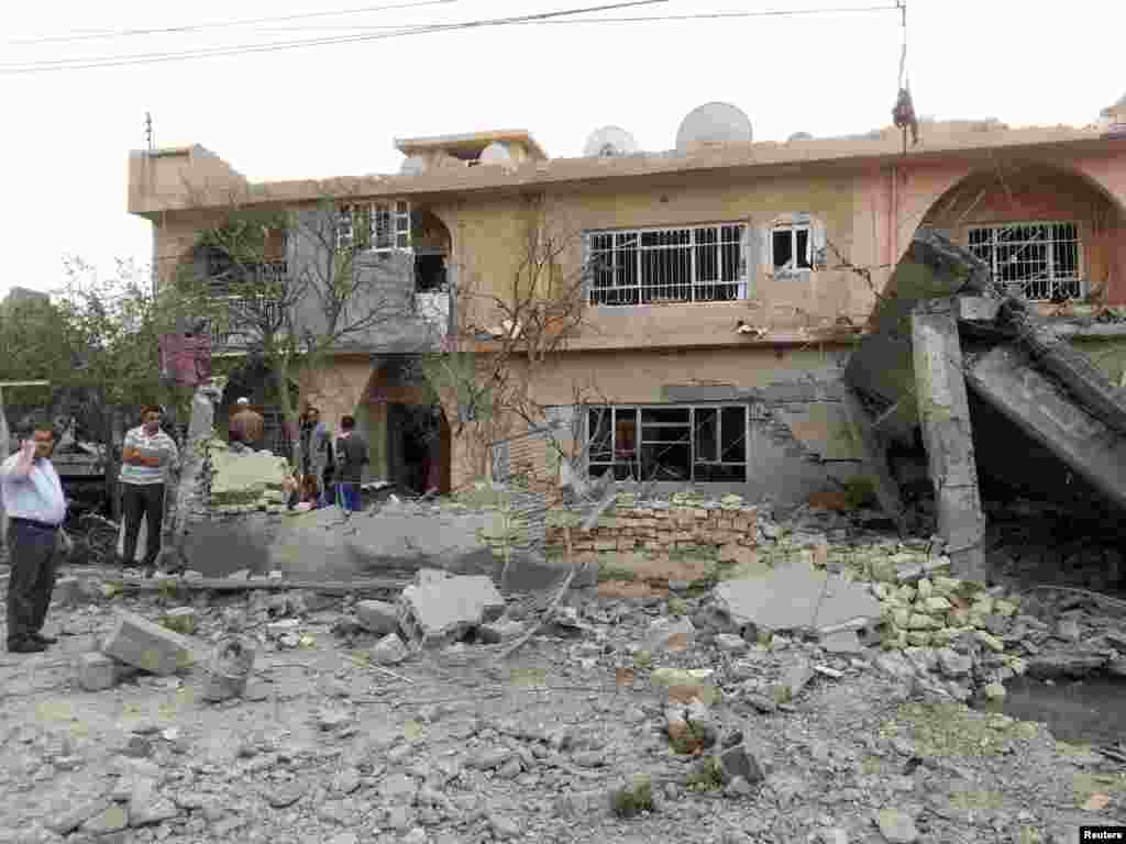 Residents gather at the site of a bomb attack in the town of Tuz Khurmatu, north of Baghdad, Oct. 31, 2013. 