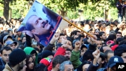 Protesters gather on Tunis' main avenue after a Tunisian opposition leader critical of the Islamist-led government was gunned down as he left home, February 6, 2013. 