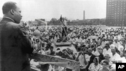FILE - Dr. Martin Luther King Jr. speaks to residents at the Robert Taylor Homes on Chicago's South Side, July 24, 1965.
