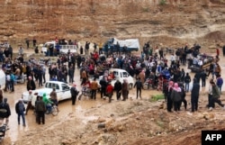 Syrians wait to be evacuated from the rebel-held town of Rastan in a convoy of buses May 7, 2018, after rebels and civilians were granted safe passage to the rebel-held town of Jarabulus, in Aleppo province, following a new deal between rebel fighters and the government.