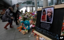 Portraits of two plane crash victims Natalia Soldatulina and Alexandra Pilip are placed near flowers and toys at an entrance of Pulkovo airport outside St. Petersburg, Russia, Nov. 4, 2015.