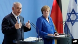 German Chancellor Angela Merkel, right, and Israel's Prime Minister Benjamin Netanyahu, left, address the media during a joint press conference as part of a meeting at the Chancellery in Berlin, Germany, Monday, June 4, 2018. 