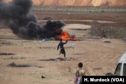 Palestinian teenagers throw rocks towards the Israeli border, often in a symbolic attack as the rocks on this day generally to not reach the fence, May 14, 2018 in the Gaza Strip.