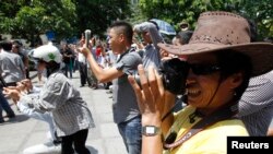 FILE - Blogger Nguyen Huu Vinh, front, takes photos while attending an anti-China protest in Hanoi.
