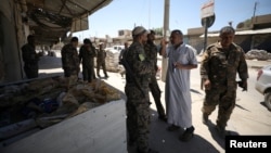 Syrian Democratic Forces fighters gather in the town of Tabqa, Syria, after the SDF captured it from Islamic State militants this week, May 12, 2017.