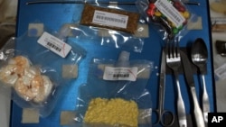 FILE - A tray similar to those used in space flight displays a sample of foods available to astronauts.