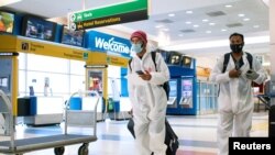 Dos viajeros recorren los pasillos del aeropuerto internacional JFK de Nueva York, EE. UU., el 21 de diciembre de 2021.