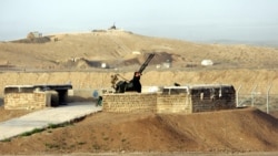 A security man stands next to an anti-aircraft gun as he scans around Iran's nuclear enrichment facility in Natanz, 300 kms 186 (miles) south of capital Tehran, Iran, Monday April, 9, 2007. Iran announced Monday that it has begun enriching uranium with 3