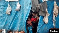 Displaced Syrian children look out from their tents at Kelbit refugee camp, near the Syrian-Turkish border, in Idlib province, Syria, Jan. 17, 2018.