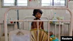 FILE - A girl, who fell sick after consuming contaminated meals given to children at a school on Tuesday, rests inside a hospital in the eastern Indian city of Patna, July 18, 2013.