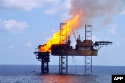 Foto yang dirilis PTTEP Australasia tampak kobaran api di anjungan pengeboran West Atlas (kanan) dan platform kepala sumur (wellhead) (kiri) sekitar 250 kilometer barat laut pantai Australia, 2 November 2009.
