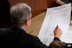 Sen. Roy Blunt, R-Mo., left, signs off on an official tally following a joint session of Congress to count Electoral College votes in Washington, Jan. 6, 2017.