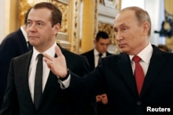Russian President Vladimir Putin and Prime Minister Dmitry Medvedev walk after the president delivered his annual state of the nation address at the Kremlin in Moscow, Dec. 1, 2016.