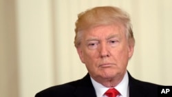 FILE - President Donald Trump listens while attending an event in the State Dining Room of the White House in Washington, May 12, 2017.