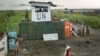 Displaced South Sudanese next to United Nations peacekeepers from Mongolia guarding the gate, at a camp at the United Nations Mission in South Sudan (UNMISS) base in the town of Bentiu, South Sudan, Sept. 22, 2014. 