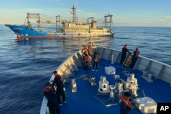 Sebuah kapal yang diduga milik milisi China menghalangi kapal penjaga pantai Filipina BRP Cabra saat mendekati Second Thomas Shoal di Laut Cina Selatan yang disengketakan pada 10 November 2023. (Foto: AP)