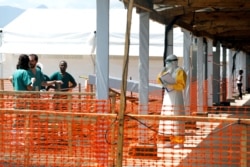 FILE - A health worker dressed in a protective suit talks to medical staff at the newly constructed MSF (Doctors Without Borders) Ebola treatment center in Goma, Democratic Republic of Congo, Aug. 4, 2019.