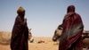 Women wait to load their carts with bags of rice and bottles of cooking oil at a food distribution center run by the Spanish NGO Accion contra el Hambre (Action Against Hunger) in Tarenguel, Gorgol region, Mauritania, May 30, 2012.
