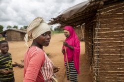 A young woman poses for pictures in the community of Marupa, a relocation center for internally displaced families in the Chiure district of Mozambique, on Feb. 23, 2021.